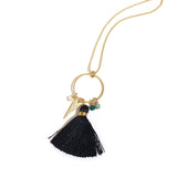 close up tassel necklace with black silk tassel and gold charms