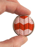 Cali pink and red zig-zag chevron pattern hand embroidered brooch - held to show scale